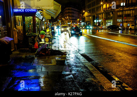 Ein Mann schläft auf einem Gehweg in einer regnerischen Nacht am 17. September 2016 in Paris, Frankreich. Stockfoto