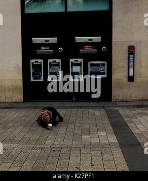 Eine Frau liegt auf der Straße, um Geld betteln vor Leuten und Geldautomaten auf der Champs Elysees, Paris, Frankreich Am 15. September 2016. Stockfoto