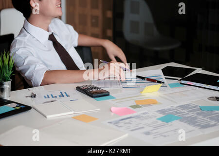 Junge asiatische Geschäftsmann in Büro- und Lächeln im Gesicht sitzen, selektive konzentrieren. Stockfoto