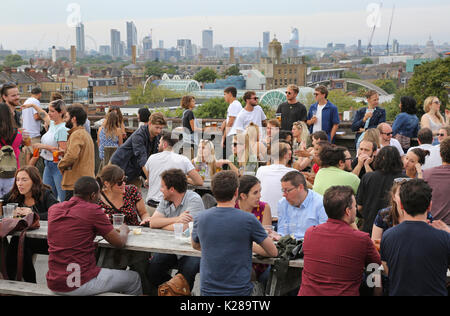 Kunden bei Frank's Café, das berühmte Dachterrasse mit Bar und Restaurant im Parkhaus in Peckham, UK, mit Blick auf die Skyline von London. Stockfoto