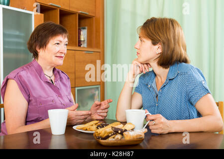 Reife Frau und ihre Tochter Tee-trinken und in einer Diskussion Stockfoto