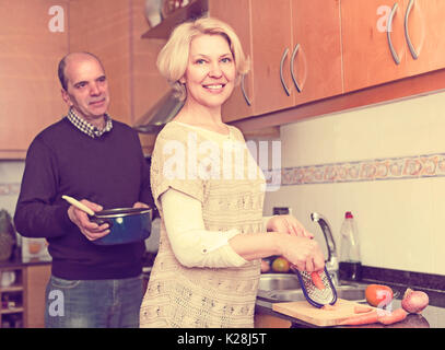 Glücklich lächelnd Senior Ehegatten Vorbereitung Mahlzeit zusammen in der Küche zu Hause Stockfoto