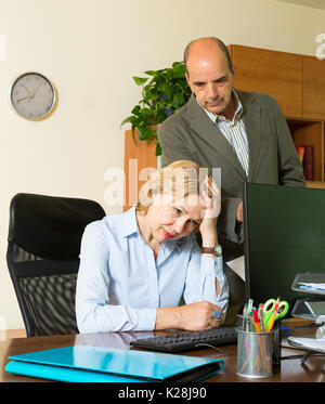 Büro Szene mit verärgerten Chef und sorglosen Jahren Sekretär Stockfoto