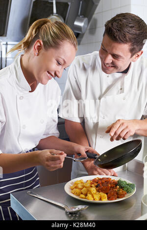 Koch anweist Trainee In Restaurantküche Stockfoto