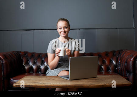 Portrait der Unternehmerin Arbeiten am Laptop im Internet Cafe Stockfoto