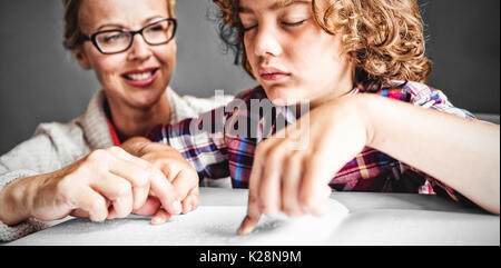 Lehrer mit Junge mit Braille zu lesen Stockfoto