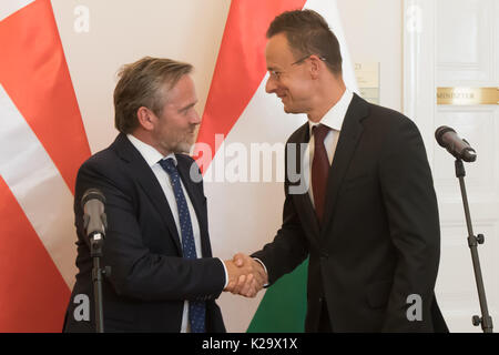 Budapest. 29 Aug, 2017. Der dänische Außenminister Anders Samuelsen (L) rüttelt Hände mit dem Ungarischen Minister für Auswärtige Angelegenheiten und Handel, Peter Szijjarto auf einer Pressekonferenz nach dem Treffen in Budapest, Ungarn, am 29. August 2017. "Das Ziel beider Länder ist es, die Wettbewerbsfähigkeit der EU zu stärken und die Europäische Sicherheit wiederherzustellen", sagte Szijjarto. "Wir sind uns darin einig, dass die illegale Migration und Terrorismus die schweren Herausforderungen der kommenden Periode für die EU sein", erklärte er. Credit: Attila Volgyi/Xinhua/Alamy leben Nachrichten Stockfoto