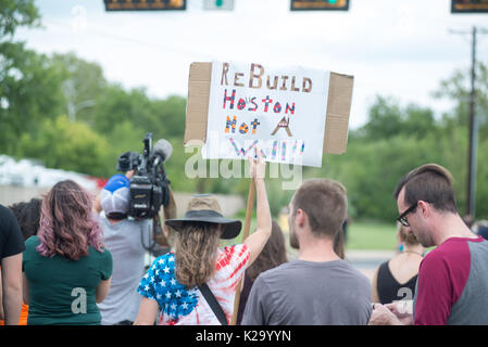 Austin, Texas, USA. 29 August, 2017. Hält eine Frau ein Zeichen sagt Präsident Donald Trump Houston nicht eine Grenzmauer in Austin, wo er besuchte das Emergency Operations Center Unterstützung Hurrikan Harvey wieder aufzubauen. 29 Aug, 2017. Credit: Sandy Carson/ZUMA Draht/Alamy leben Nachrichten Stockfoto