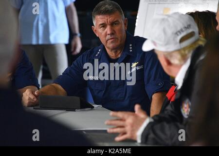 Us-Präsident Donald Trump ist unterrichtet, die die Küstenwache Atlantischen Gebiet Commander Vice Admiral Karl Schultz während eines Hurrikans Harvey Antwort im Fire Station 5 August 29, 2017 in Corpus Christi, Texas. Stockfoto