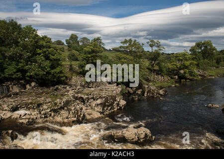 Blauer Himmel über Cascading Wasser & Kalksteinfelsen bei Sunny, Scenic Linton fällt Wasserfall über River Wharfe, Grassington, Yorkshire Dales, England, UK. Stockfoto