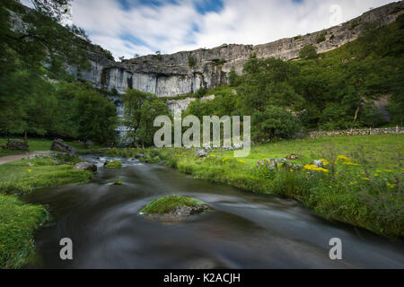 Schönen Sommerabend Ansicht der wirbelnden Wasser von Malham Beck & the Cove, eine große, geschwungene Kalksteinfelsen - Malhamdale, Yorkshire Dales, England, UK. Stockfoto