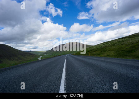Island - Straße Kurve in majestätischen isländische Landschaft mit hohen grünen Bergen Stockfoto