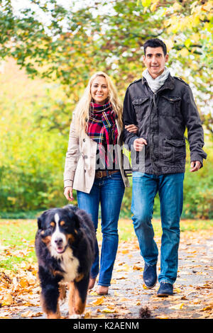 Frau und Mann mit Hund in Herbst Spaziergang Stockfoto