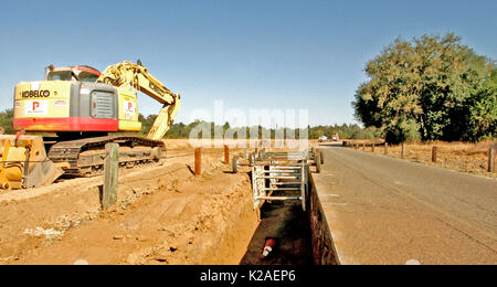 Raupenbagger am Graben ORT UND BLICK ENTLANG GRABEN MIT SICHERHEIT TRAGGERÜST, Kalifornien Stockfoto