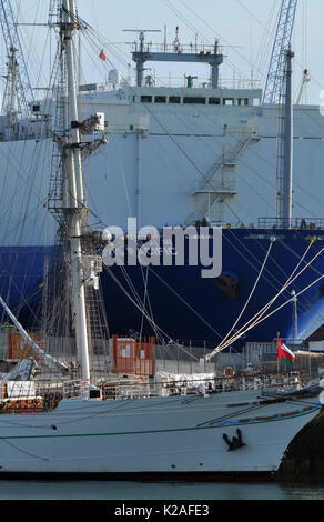 Ein modernes Auto, Schiff transpoters und einem alten segeln Schiff zusammen Neben an den Southampton Docks de port Kontrast zwischen neuen und alten Stockfoto