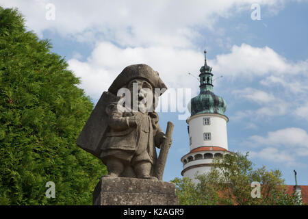 Statue von einem Zwerg durch Austrian-Bohemian barocken Bildhauer Matthias Bernhard Braun im Garten des Schlosses von Nové Město nad Metují in Ostböhmen, Tschechische Republik. Der Turm des Schlosses ist im Hintergrund zu sehen. Stockfoto