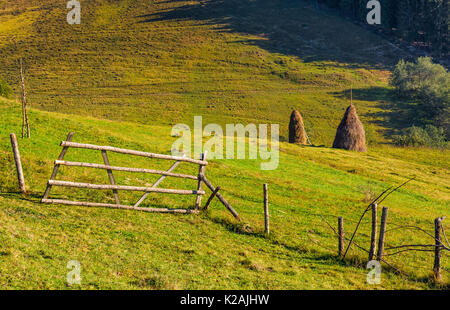 Hay Stacks hinter dem Zaun auf den ländlichen Bereich. schöne Landschaft Landschaft der Karpaten im frühen Herbst morgen Stockfoto