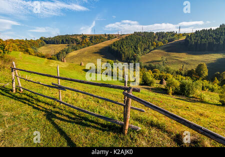 Hay Stacks hinter dem Zaun auf den ländlichen Bereich. schöne hügelige Landschaft Landschaft der Karpaten in der Nähe von Forest im frühen Herbst morgen Stockfoto