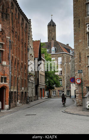 Ein Radfahrer fährt in einer ruhigen, schmalen Seitenstraße in der mittelalterlichen Stadt Brügge/Brügge, Westflandern, Belgien Stockfoto