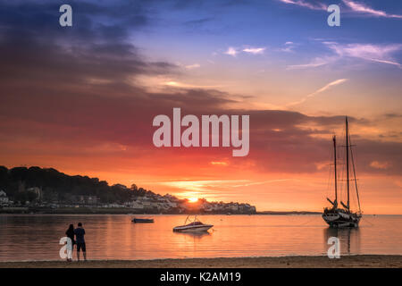 Die Sonne hinter dem Dorf Appledore, wie die Flut von Brötchen am Strand von instow in North Devon. Stockfoto