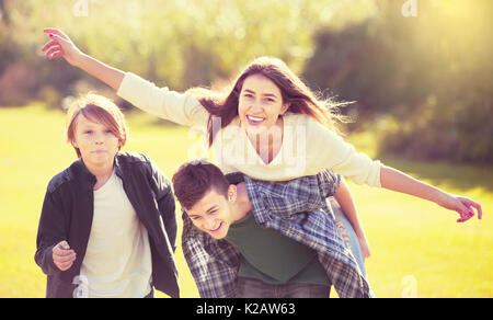 Gruppe positiver teenage Freunden plaudern und Spaß im Park. Getonten Bild Stockfoto