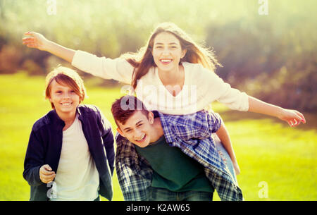 Mädchen mit zwei Jungen im Herbst park Posing und lächelnd Stockfoto