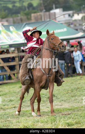 Juni 3, 2017 Machachi, Ecuador: junge kechwa Junge in traditioneller Cowboy outfit Arbeiten das Lasso Natur vom Pferderücken aus Stockfoto