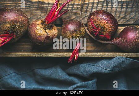 Rohe organische lila und rote Beete in Holzkiste Stockfoto