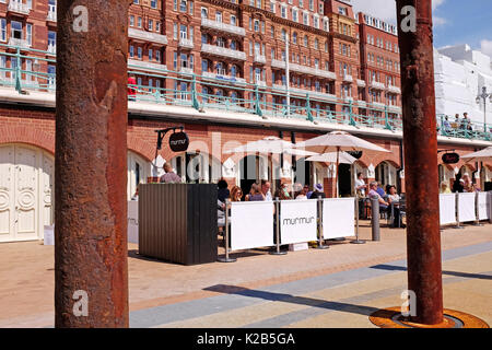 Die Menschen essen außerhalb des neu geöffneten Murmeln Restraurant auf Brighton Seafront von Küchenchef Michael Bremner in der Nähe der West Pier Stockfoto