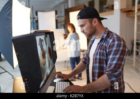 Auf der Suche durch die Fotos im Studio Stockfoto