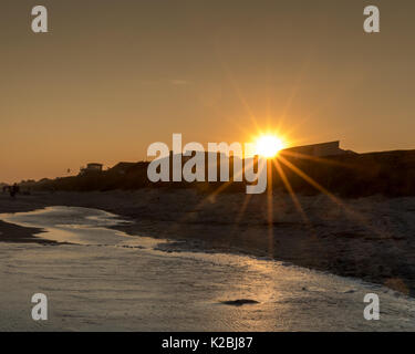 Sonne über Emerald Isle Ocean - Am Strand Häuser am Horizont Wellen brechen Tide kommen Während der Strand Ferienhäuser @OBX genommen Stockfoto