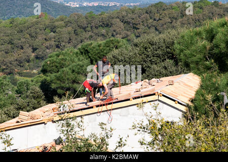 Dachdecker bei der Arbeit der Installation von Fliesen auf einem neuen Haus in der Provence, Frankreich Stockfoto