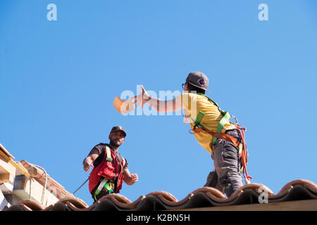 Dachdecker bei der Arbeit der Installation von Fliesen auf einem neuen Haus in der Provence, Frankreich Stockfoto