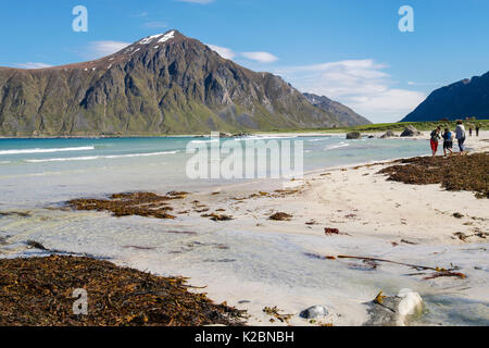 Touristen am ruhigen Sandstrand Skagsanden Strand. Flakstad, Insel Flakstadøya, Lofoten Inseln, Nordland, Norwegen, Skandinavien Stockfoto