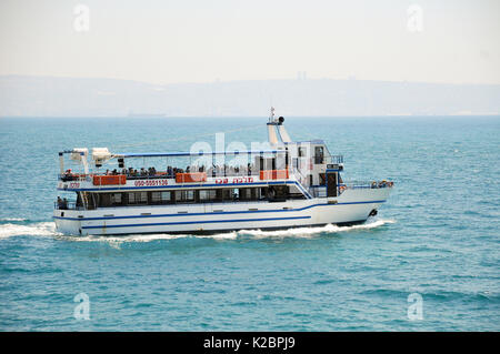 Touristenboot aus dem Alten Hafen von Akko, Israel. Mount Carmel und Haifa im entfernten Hintergrund Stockfoto