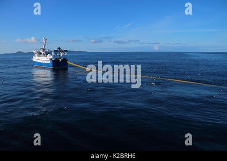 Fischereifahrzeug" Ocean Harvest', die in ruhigen Bedingungen mit Fair Isle in der Ferne. Nordsee, UK, August 2014. Eigentum veröffentlicht. Alle nicht-redaktionelle Verwendungen muß einzeln beendet werden. Stockfoto