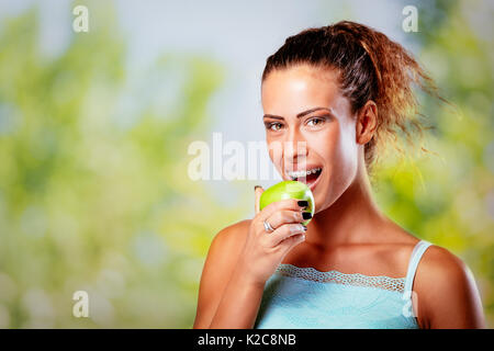 Lächelnde junge Frau mit Klammern auf weiße Zähne holding Green Apple und Kamera. Stockfoto