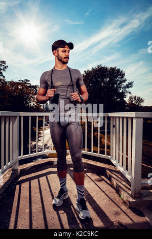 Junge Sportler Ausruhen nach der Ausbildung an der Brücke und weg schauen. Stockfoto