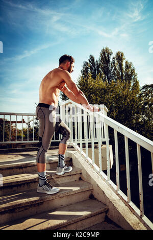 Junge Sportler Ausruhen nach der Ausbildung an der Brücke und weg schauen. Stockfoto