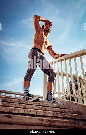 Junge Sportler Ausruhen nach der Ausbildung an der Brücke und weg schauen. Stockfoto