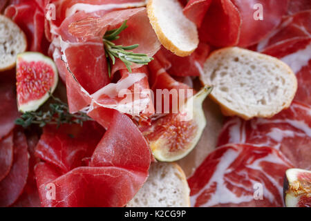 Italienische Antipasti und Vorspeisen. Board mit Scheiben Prosciutto, Salami, getrocknetes Schweinefleisch, Salami Schinken mit Kräutern. Stockfoto