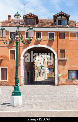 Auf der Suche durch einen Bogen in die Calle Colonna, Castello, Venice, Italien am Tag waschen von der Riva dei Sette Martiri mit einem Venezianischen Lamp Post im foreg Stockfoto