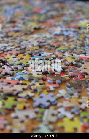 Puzzle Stück zufällig über einen Tisch verstreut Stockfoto