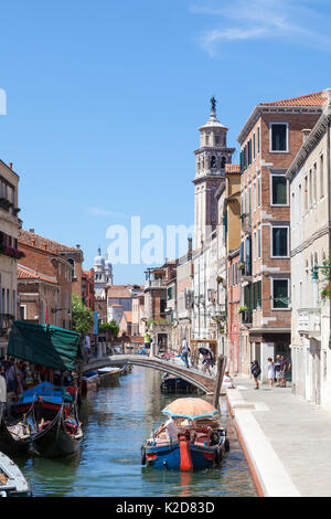 Der malerische Kanal von Rio de San Barnaba, Dorsoduro Venedig, Venetien, Italien mit angelegten Gondeln und eine funktionierende Boot mit Sonnenschirm als Protec Stockfoto