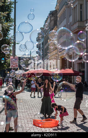 Berlin, Deutschland. August 29, 2017: Mädchen machen Seifenblasen an einem sonnigen Tag auf der Straße in Berlin, Deutschland. Stockfoto