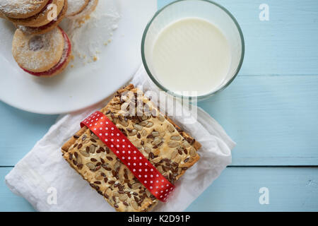 Zwei Arten von Cookies mit Glas Milch. Auf weiße Platte und auf weißen Serviette Gewebe von puff Teig gemacht. Von der Ansicht von oben Stockfoto
