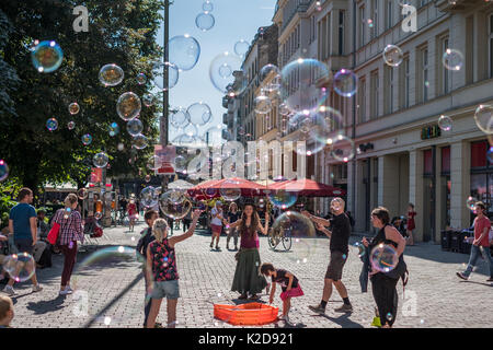 Berlin, Deutschland. August 29, 2017: Mädchen machen Seifenblasen an einem sonnigen Tag auf der Straße in Berlin, Deutschland. Stockfoto