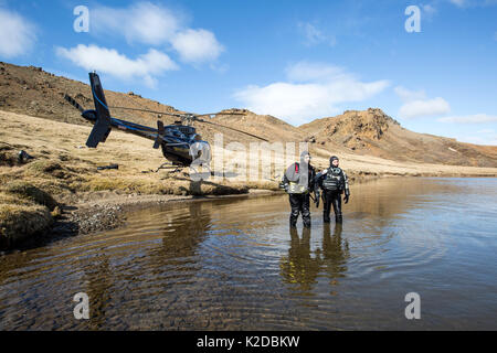 Heli-Tauchen, gehen ins Wasser für ein Scouting tauchen in einem Bergsee, Island Stockfoto