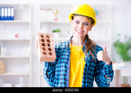 Frau mit Ziegel in der Bauwirtschaft Konzept Stockfoto