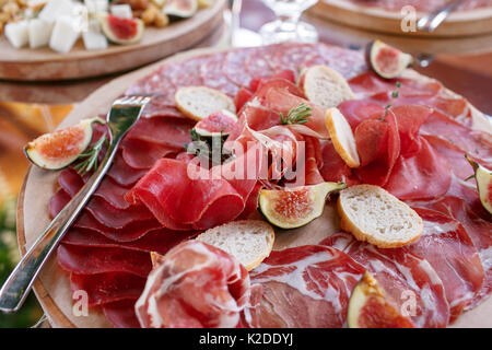 Italienische Antipasti und Vorspeisen. Board mit Scheiben Prosciutto, Salami, getrocknetes Schweinefleisch, Salami Schinken mit Kräutern. Stockfoto